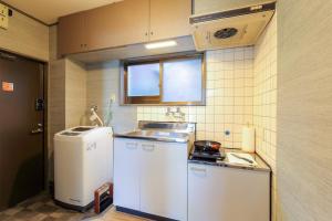 een kleine keuken met een spoelbak en een koelkast bij Kulton Moct Kenroku in Kanazawa +47 foto's