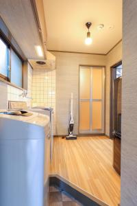 een keuken met een koelkast en een hardhouten vloer bij Kulton Moct Kenroku in Kanazawa
