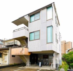 een groot wit gebouw met een trap erop bij Kulton Moct Kenroku in Kanazawa
