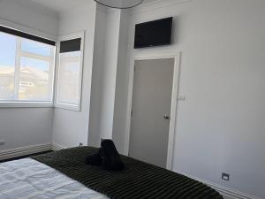 a bedroom with a bed and a television on the wall at Stylish Petone Stay in Lower Hutt