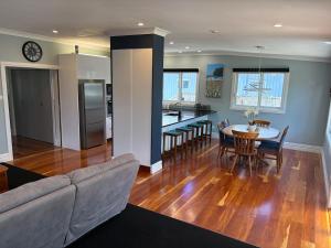 a living room and kitchen with a couch and a table at Stylish Petone Stay in Lower Hutt