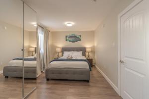 een slaapkamer met twee bedden en een spiegel bij Comfort Tenacity in Yellowknife