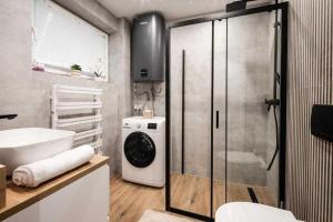 un bagno con lavandino e lavatrice di Hostel Migrand a Stettino