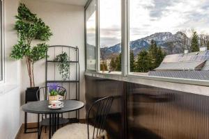 un tavolo e delle sedie in una stanza con una finestra di Hostel Migrand a Stettino