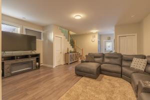 een woonkamer met een bank en een flatscreen-tv bij Comfort Tenacity in Yellowknife