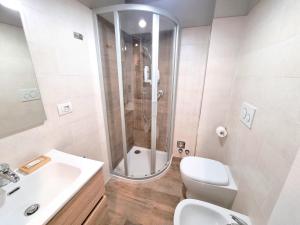 a bathroom with a shower and a toilet and a sink at Moda Apartments 38 in Sestriere +2 photos