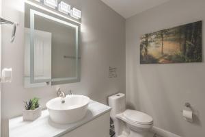 een witte badkamer met een wastafel en een toilet bij Comfort Tenacity in Yellowknife +27 foto's