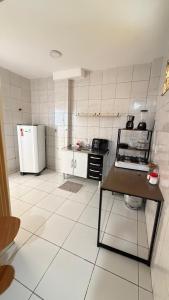 een keuken met een koelkast en een tafel. bij Paulinos Flat 02, Ubajara CE in Ubajara