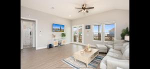 a living room with a couch and a ceiling fan at Stunning Beach Front House in Crystal Beach