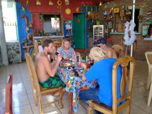 een groep mensen die rond een tafel in een restaurant zitten bij Hostel María Ometepe in Santa Cruz +69 foto's