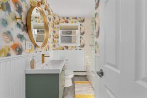 a bathroom with a sink and a mirror and a toilet at The Return to Self - Walk to Historic Downtown in Warren
