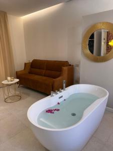 a bath tub in a living room with a couch at Sofì Luxury Suite in Iglesias