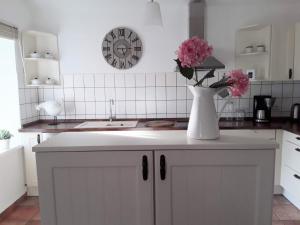 a kitchen with a vase with pink flowers on a counter at Apartment Marie-Luise by Interhome in Ferchesar
