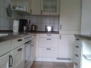 a white kitchen with white cabinets and a sink at Apartment Marie-Luise by Interhome in Ferchesar +3 photos