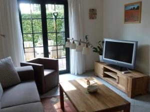 a living room with a television and a coffee table at Apartment Am Marsfeld by Interhome in Borkheide