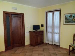 a living room with a door and a computer on a desk at La Macina di Bettona in Bettona
