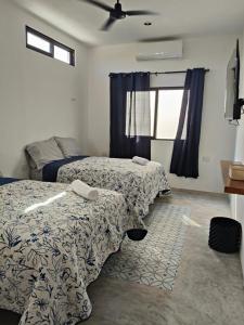 a bedroom with two beds and a window at La Conchita de Sisal 7 in Sisal +2 photos