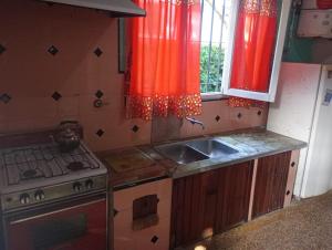 a kitchen with a sink and a stove at La Carioca in Villa Gesell