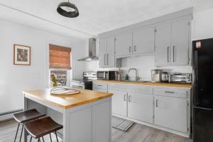 a kitchen with white cabinets and a black refrigerator at The Return - Multi-Unit Retreat - Sleeps 16 - Spa in Warren