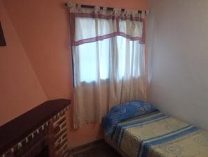 a bedroom with a window with a bed and a crib at La Carioca in Villa Gesell