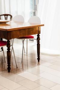 a wooden table with chairs around it on a tile floor at Apartment Studio by Interhome in Schernfeld