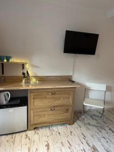 een bureau met een stoel en een televisie aan de muur bij Willa Avita in Karpacz