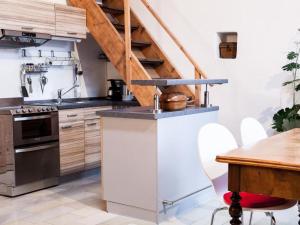 a kitchen with wooden cabinets and a staircase at Apartment Studio by Interhome in Schernfeld