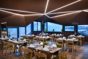 a restaurant with tables and chairs and windows at Hotel Vinotel Gospoja in Vrbnik