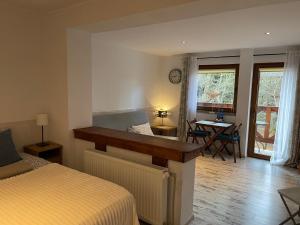 een slaapkamer met een bed, een bureau en een tafel bij Willa Avita in Karpacz