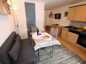 a living room with a table and a couch and a kitchen at Apartment Igel by Interhome in Bad Bayersoien