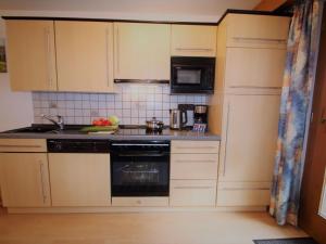 a kitchen with white cabinets and a stove top oven at Apartment Igel by Interhome in Bad Bayersoien +25 photos