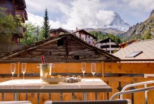 una mesa con un tazón de comida y copas de vino en Haus Welcome, en Zermatt