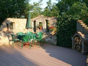 a table and chairs with a green umbrella on a deck at Apartment FeWo Bärli by Interhome in Bad Bayersoien