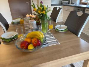 a wooden table with a bowl of fruit on it at Apartment Gästehaus Siebert by Interhome in Bad Brambach