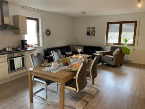 a kitchen and living room with a wooden table and chairs at Apartment Gästehaus Siebert by Interhome in Bad Brambach +30 photos
