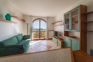 a living room with a green couch and a kitchen at Blu Garda View in Polpenazze del Garda