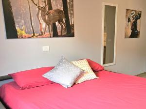 a bedroom with a pink bed with two pillows on it at Moda Apartments 69 in Sestriere +4 photos