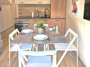 a dining room table with chairs and a kitchen at Moda Apartments 69 in Sestriere