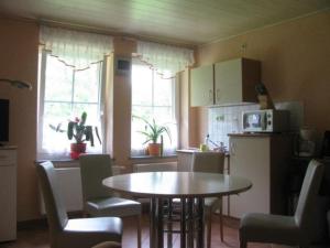 a kitchen with a table and some chairs and a table and a kitchen with at Apartment Saydaer Höhe by Interhome in Sayda