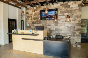 a bar with a tv on a brick wall at OENO WINE LODGE Valle de Guadalupe in Valle de Guadalupe