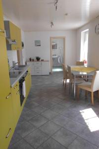 a kitchen and dining room with a table and yellow cabinets at Apartment mit Terrasse by Interhome in Sayda