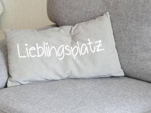 a white pillow sitting on a couch with the words volunteering square at Apartment Haus Budinger by Interhome in Alf