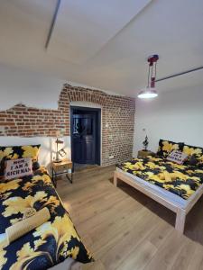 ein Schlafzimmer mit zwei Betten und einer Ziegelwand in der Unterkunft Apartament klimatyczny in Piece