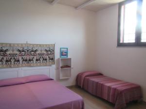 1 dormitorio con 2 camas y ventana en B&B Su Tostainu, en Teulada