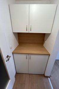 a small kitchen with white cabinets and a wooden shelf at Apartment Haus Budinger by Interhome in Alf