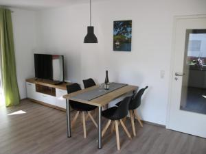 a dining room with a table and chairs and a television at Apartment Haus Budinger by Interhome in Alf