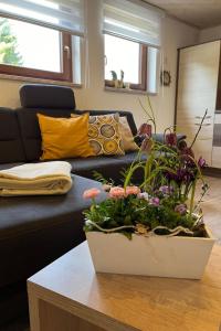 a living room with a couch and a table with flowers at Apartment FeWo Siebert by Interhome in Bad Brambach