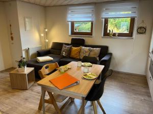 a living room with a table and a couch at Apartment FeWo Siebert by Interhome in Bad Brambach