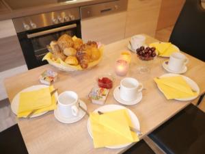 a table with yellow napkins and cups and a bowl of food at Apartment FeWo Siebert by Interhome in Bad Brambach