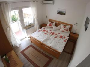a bedroom with a bed with red roses on it at Apartment Haus Budinger by Interhome in Alf